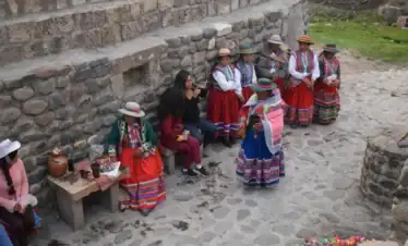 Viajeros compartiendo con mujeres de la comunidad del Colca en experiencia vivencial.