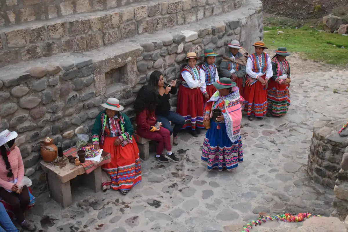 Viajeros compartiendo con mujeres de la comunidad del Colca en experiencia vivencial.